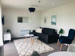 a living room with a couch and a table at 1 & 2 Bedroom Shield House Apartments Sheffield Centre in Sheffield