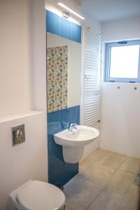 La salle de bains est pourvue de toilettes blanches et d'un lavabo. dans l'établissement Olimp 35, à Olimp
