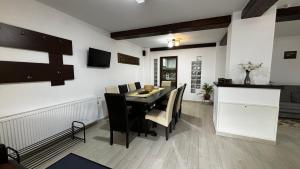 a dining room with a black table and chairs at Skyline Villa in Azuga