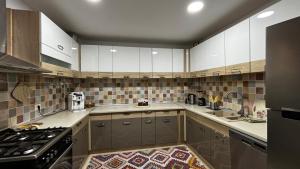 a large kitchen with white cabinets and a stove at Skyline Villa in Azuga