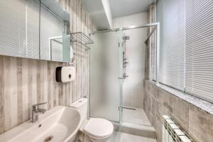 a bathroom with a white toilet and a sink at Tropica Inn Hotel in Yerevan +26 photos