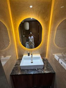 a man taking a picture of a bathroom with a sink at The LUTF in New Delhi