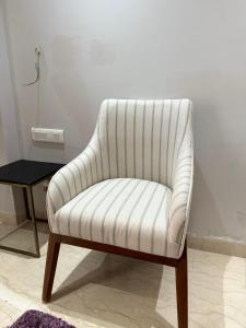 a white chair in a room with a table at The LUTF in New Delhi