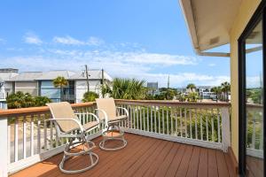 two chairs on a deck with a view of the ocean at Beach Side- Harbor View in Destin