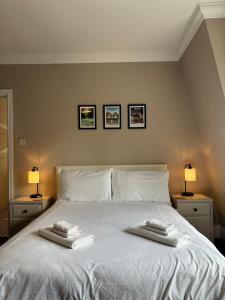 1 dormitorio con 1 cama blanca y 2 toallas en Large West Side Room above G Grace & Son, en Tring