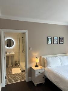 a bedroom with a bed and a bathroom with a shower at Large West Side Room above G Grace & Son in Tring