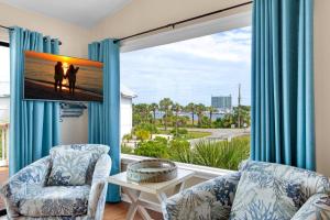 a living room with two chairs and a large window at Beach Side- Harbor View in Destin