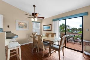 a dining room with a table and chairs and a balcony at Beach Side- Harbor View in Destin