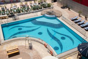 an overhead view of a large swimming pool in a hotel at Dubai Grand Hotel by Fortune, Dubai Airport in Dubai