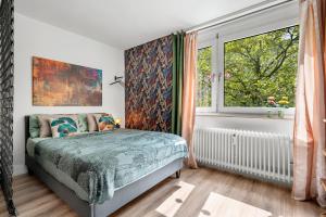 Schlafzimmer mit einem Bett und einem Fenster in der Unterkunft Urban Jungle Studio Apartment in Offenbach