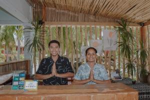 Anugerah Surf & Dive في نيمبرالا: يقوم رجلان بعمل اليوغا في الغرفة
