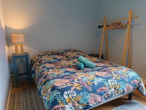 a bedroom with a bed with a colorful bedspread at Charmante Maison à Coutances in Coutances