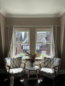 two chairs and a table in front of a window at Large East Side Room above G Grace & Son in Tring