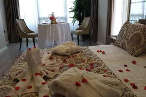 ein Bett mit Handtüchern drauf mit Rosen drauf in der Unterkunft ATAKUM PALAS OTEL in Samsun