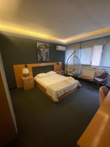 a bedroom with a bed and a chair and a fan at Samsun Osmanlı Otel in Samsun