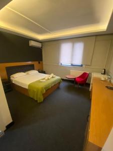 1 dormitorio con 1 cama, mesa y sillas en Samsun Osmanlı Otel en Samsun
