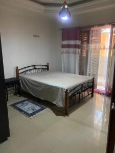 1 dormitorio con 1 cama en una habitación con ventana en Duplex T3 Bien Situé, en Annaba