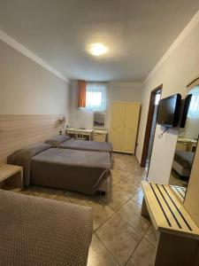 TerzignoにあるIl Castelloのベッド2台とテレビが備わるホテルルームです。