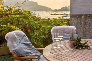 a wooden table with two glasses of wine on a balcony at Villa Claudia in Portovenere