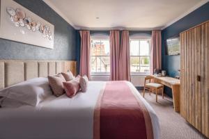 Schlafzimmer mit einem Bett, einem Schreibtisch und einem Fenster in der Unterkunft The Stroud Hotel in Stroud