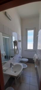 a bathroom with two sinks and two toilets at Hotel Belmar in Cattolica