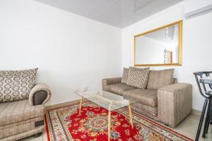 a living room with two chairs and a coffee table at Safi 1 bedroom Suite 9 in East London