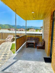 a patio with a table and benches on a deck at Cottage Marta Sadgeri in Borjomi