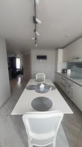 a kitchen with a white table in a room at Emporium Apartments in Rēzekne
