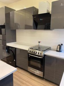 una cucina con piano cottura in acciaio inossidabile forno superiore di Private Apartments in a Home a Ejisu