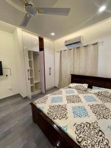1 dormitorio con 1 cama grande y ventilador de techo en Private Apartments in a Home, en Ejisu