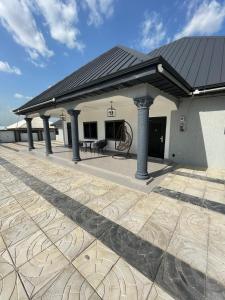 un edificio con tetto con pilastri su un patio di Private Apartments in a Home a Ejisu