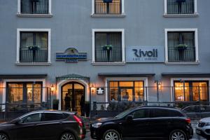 Port Rivoli Baku Luxury Boutique Hotel في باكو: سيارتين متوقفتين امام مبنى