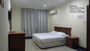 a hotel room with a bed and a sign on the wall at The Upper Deck Hotel in Kudat