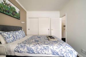 a bedroom with a large bed with blue and white sheets at Welcome To Your Secluded Luxury Abode in Auckland