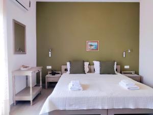 a bedroom with a large bed with two towels on it at Argiro Studios in Skala Rachoniou