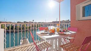 uma varanda com uma mesa e cadeiras com vista para a água em CASA NOSTRA, Port-Grimaud, Vue sur les Canaux em Grimaud