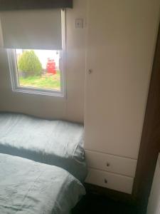 um pequeno quarto com uma cama e uma janela em BLP22C em Northampton