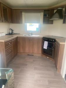uma cozinha com armários de madeira, um lavatório e um fogão em BLP22C em Northampton