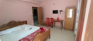 a bedroom with a bed and a table and chairs at Hotel Chemistrica Digha Near Old Digha Sea Beach - Couple Friendly in Digha