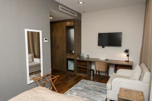 een woonkamer met een bed en een bureau met een televisie bij Port Rivoli Baku Luxury Boutique Hotel in Baku