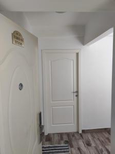 コンスタンツァにあるTomis 99 Apartの白いドアと壁に看板が付いた部屋