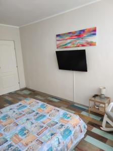 a bedroom with a bed and a tv on a wall at Tomis 99 Apart in Constanţa