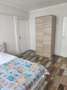 コンスタンツァにあるTomis 99 Apartのベッドルーム1室(ベッド1台、木製ドレッサー付)