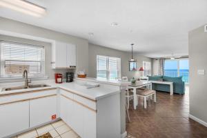 una cucina con armadi bianchi e un soggiorno di The Palms #505 a Fort Walton Beach