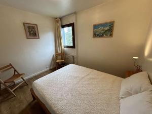um quarto com uma cama, uma cadeira e uma janela em Appartement Megève, 2 pièces, 6 personnes - FR-1-597-7 em Megève