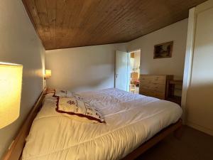 a bedroom with a white bed with a wooden ceiling at Appartement Megève, 2 pièces, 5 personnes - FR-1-597-27 in Megève