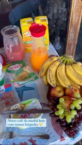 Mansão Espetacular Angra في انغرا دوس ريس: طاولة مع حفنة من الموز وبعض العصير