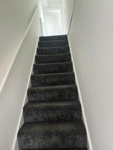 a stair case with black carpet and white walls at Duke of Albany in Weymouth