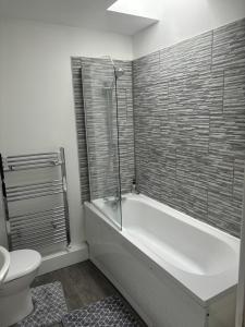 een badkamer met een wit bad en een toilet bij Duke of Albany in Weymouth