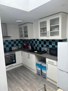 uma cozinha com armários brancos e azulejos pretos e brancos em Duke of Albany em Weymouth